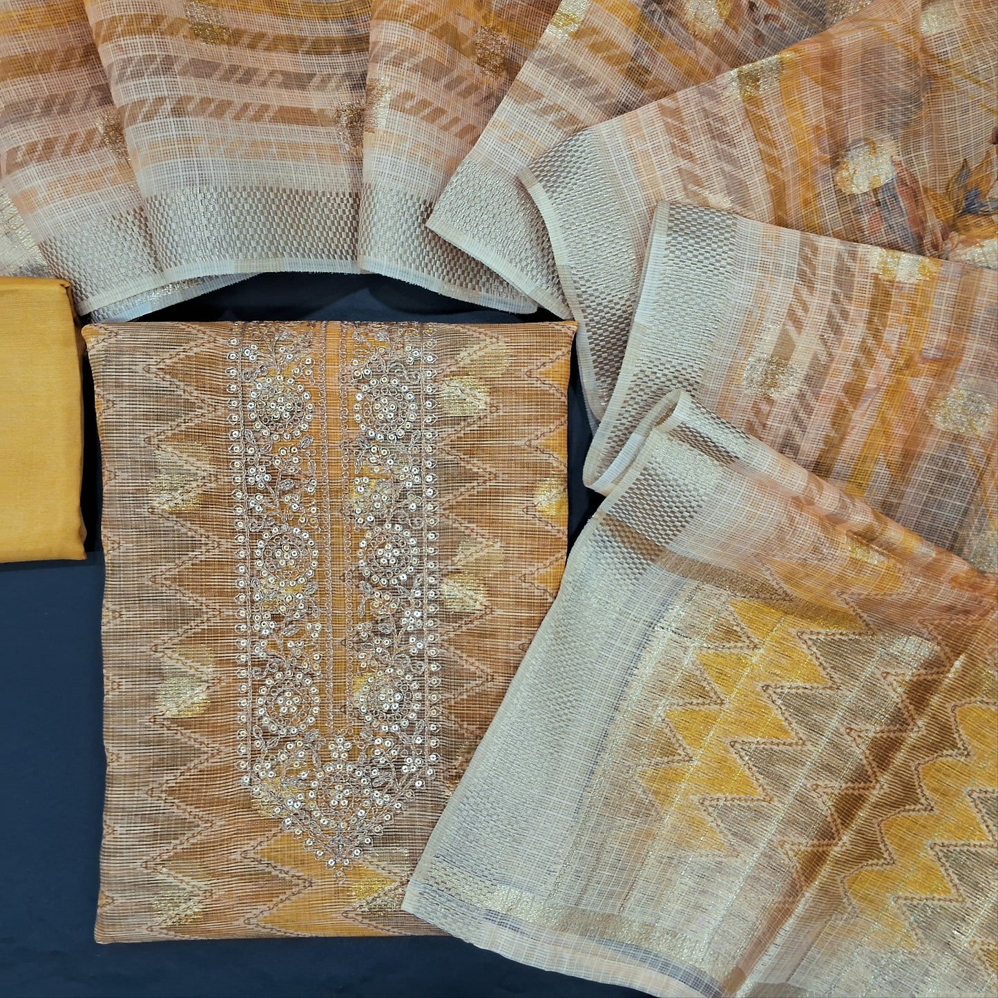 Golden beige zigzag printed premium kota unstitched salwar material, zari & sequins work on yoke, zari woven buttas on front(thin fabric, lining needed)matching silk cotton bottom, premium kota dupatta with zari buttas& gold tissue pallu. CODE AG240817