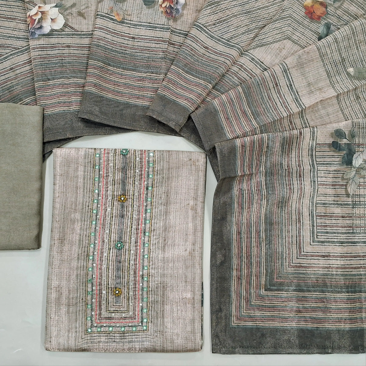 Grey shade with golden tint digital printed tissue silk cotton unstitched salwar material, faux mirror& sequins work on yoke(thin fabric, lining needed)matching santoon bottom, digital printed tissue silk cotton dupatta. CODE SP242825