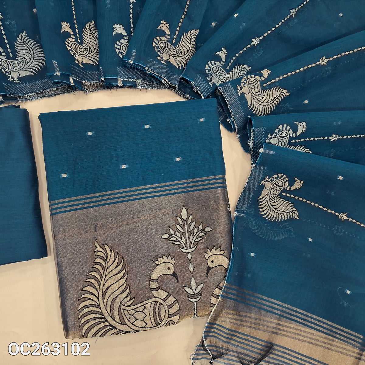 Dark teal blue silk cotton unstitched salwar material, zari weaving on yoke, buttas all over, tissue daman with zari weaving (Lightweight, Lining Needed) matching silk cotton bottom, silk cotton dupatta with gold and silver zari thread weaving. OC263102