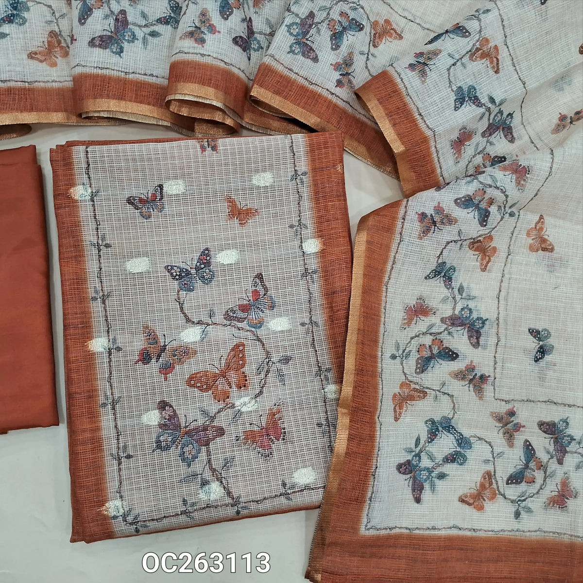 Brick red kota digital printed unstitched salwar material, zari woven buttas all over (Thin, Lightweight, Lining Needed) matching silky bottom, printed kota dupatta. OC263110