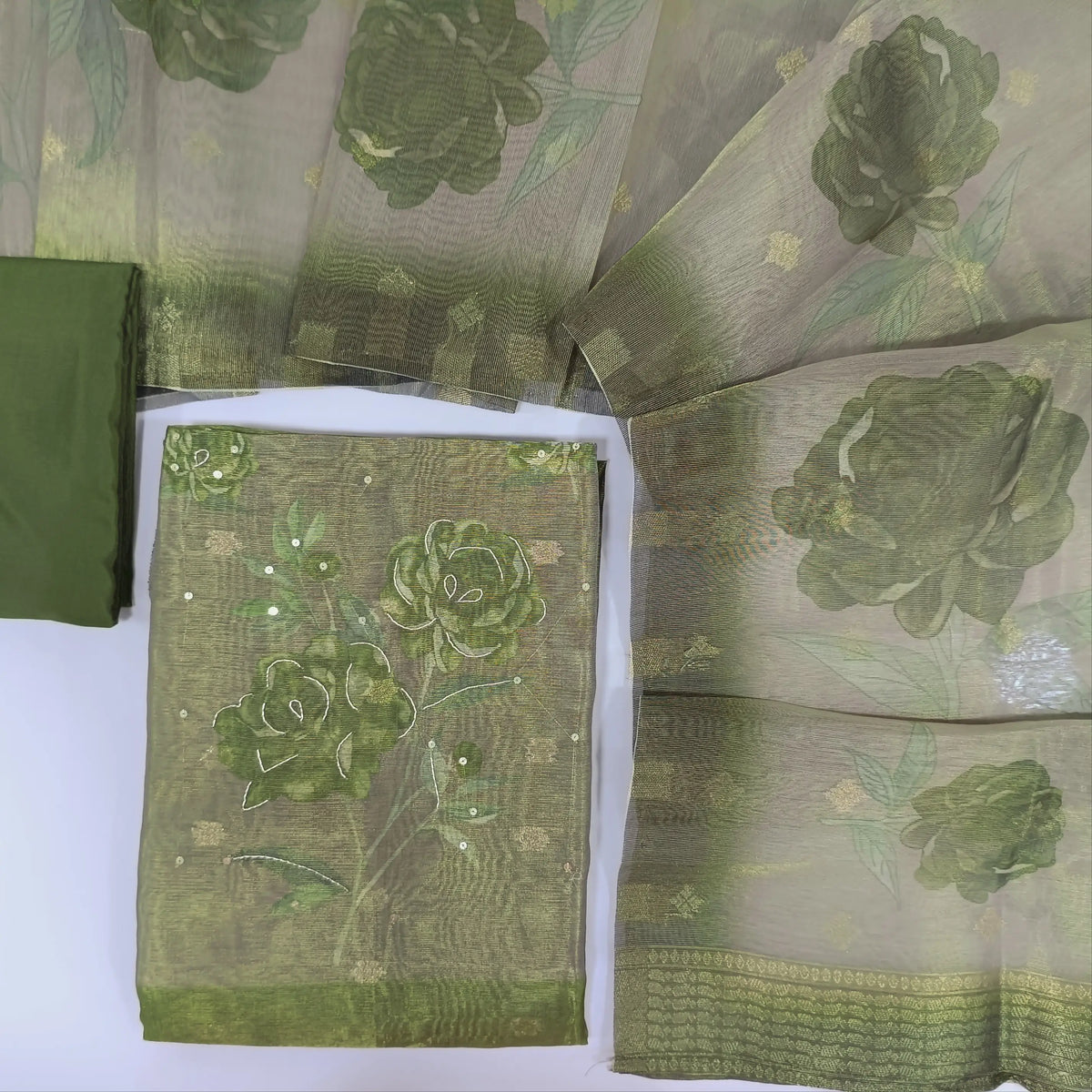 Olive green with golden tint tissue silk cotton unstitched salwar material, floral printed yoke with sequins& zardozi work, zari buttas all over(lining needed)matching silky bottom, floral printed tissue silk cotton dupatta. CODE NV241413