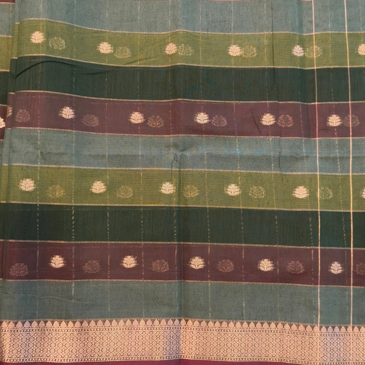 Multicoloured (Dark green & brown)soft silk cotton saree with zari woven checks & buttas all over, zari woven double side borders, tissue pallu,multicoloured running blouse with borders & buttas. NS27