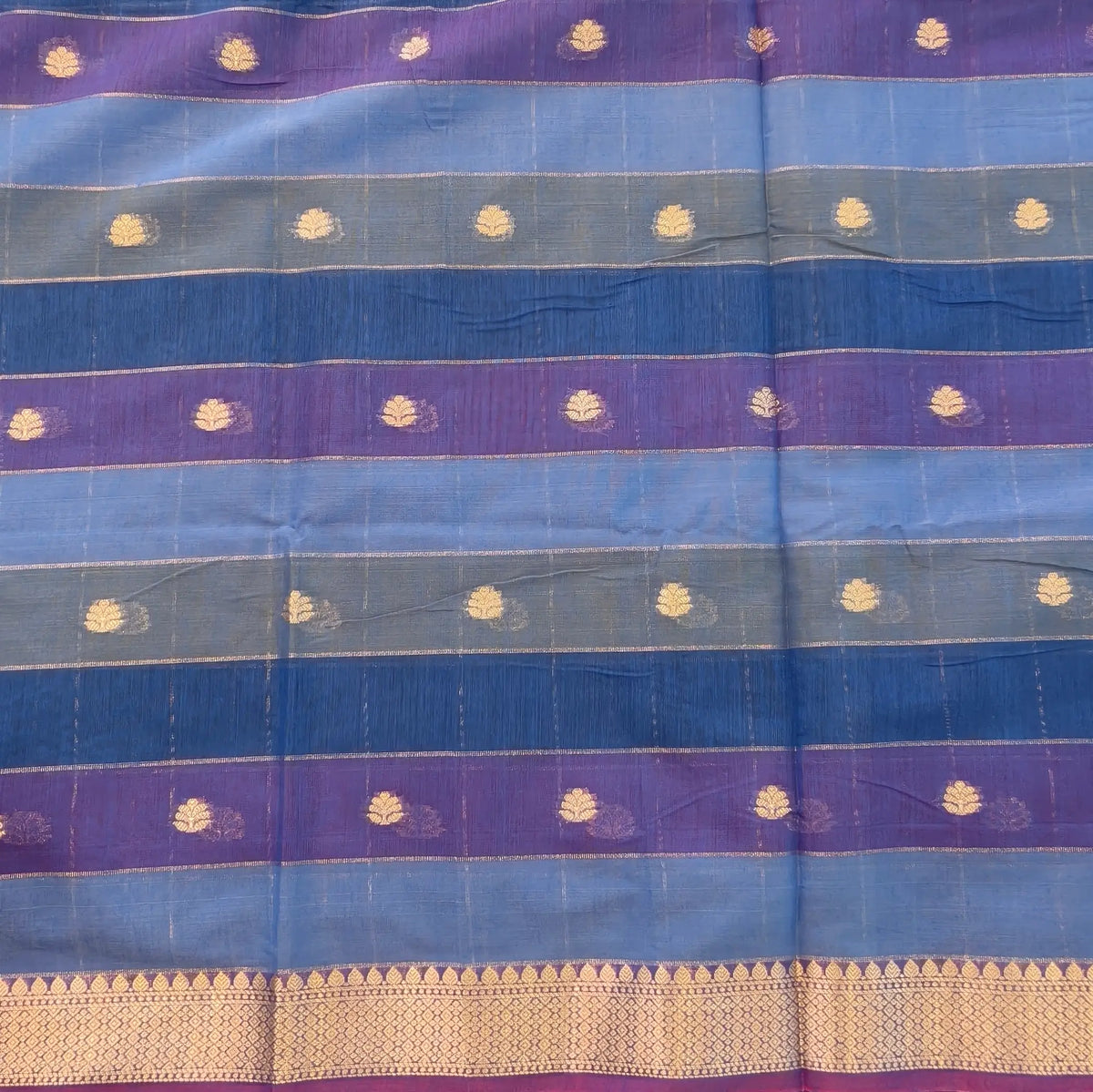 Multicoloured (Light& dark blue)soft silk cotton saree with zari woven checks & buttas all over, zari woven double side borders, tissue pallu,multicoloured running blouse with borders & buttas. NS32