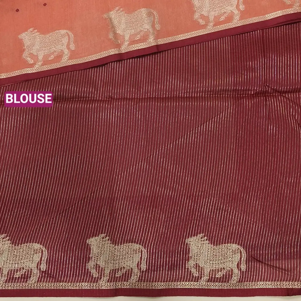 Dark peach with maroon fancy silk cotton saree with thread woven buttas all over the body of the saree, double side borders with pichwai zari short pallu and zari striped blouse with cow motif weaving. CODE NS01