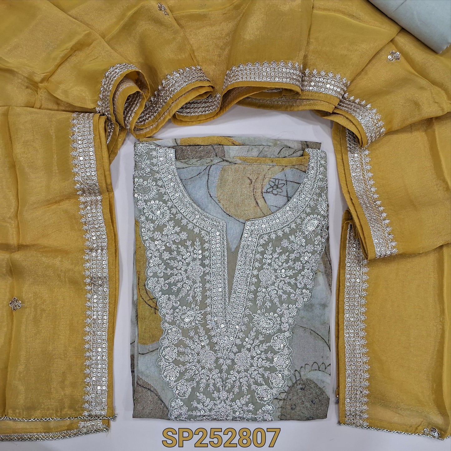 Beige tissue organza silk unstitched salwar material, printed all over, zari and sequins work on yoke (Soft, Silky, Lining Needed) Santoon Bottom, Pastel yellow tissue organza silk dupatta. SP252707