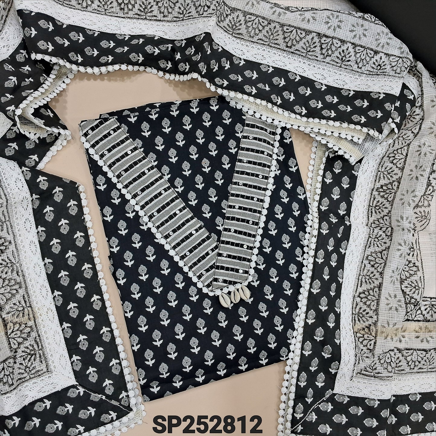 Black base printed pure cotton unstitched salwar material, V Neckline, shell detaling on yoke (Lining Optional) matching cotton bottom, Block printed kota dupatta with tapings and crochet work. SP252812
