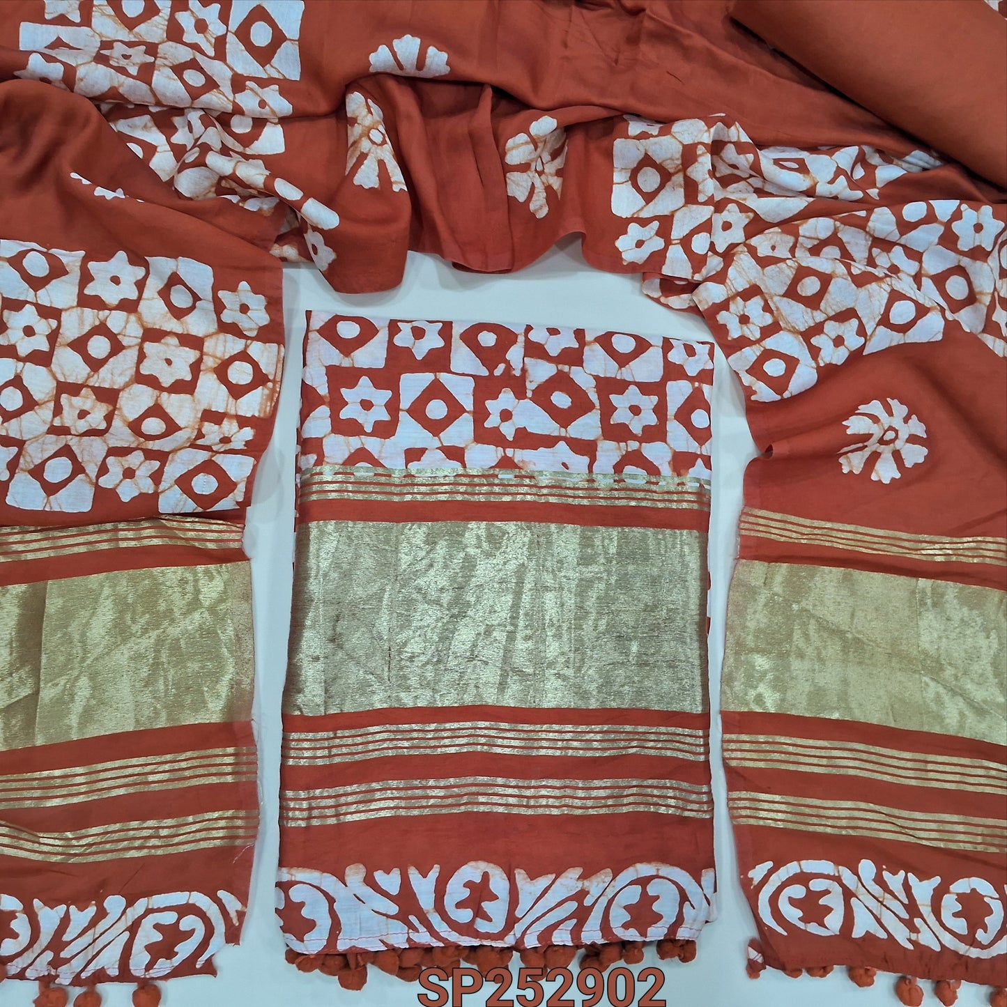 Brick Red original wax batik dyed fancy silk cotton unstitched salwar material, tapings and tissue on daman (Soft, Lining Needed) Matching spun cotton bottom, batik dyed soft silk cotton dupatta. SP252902