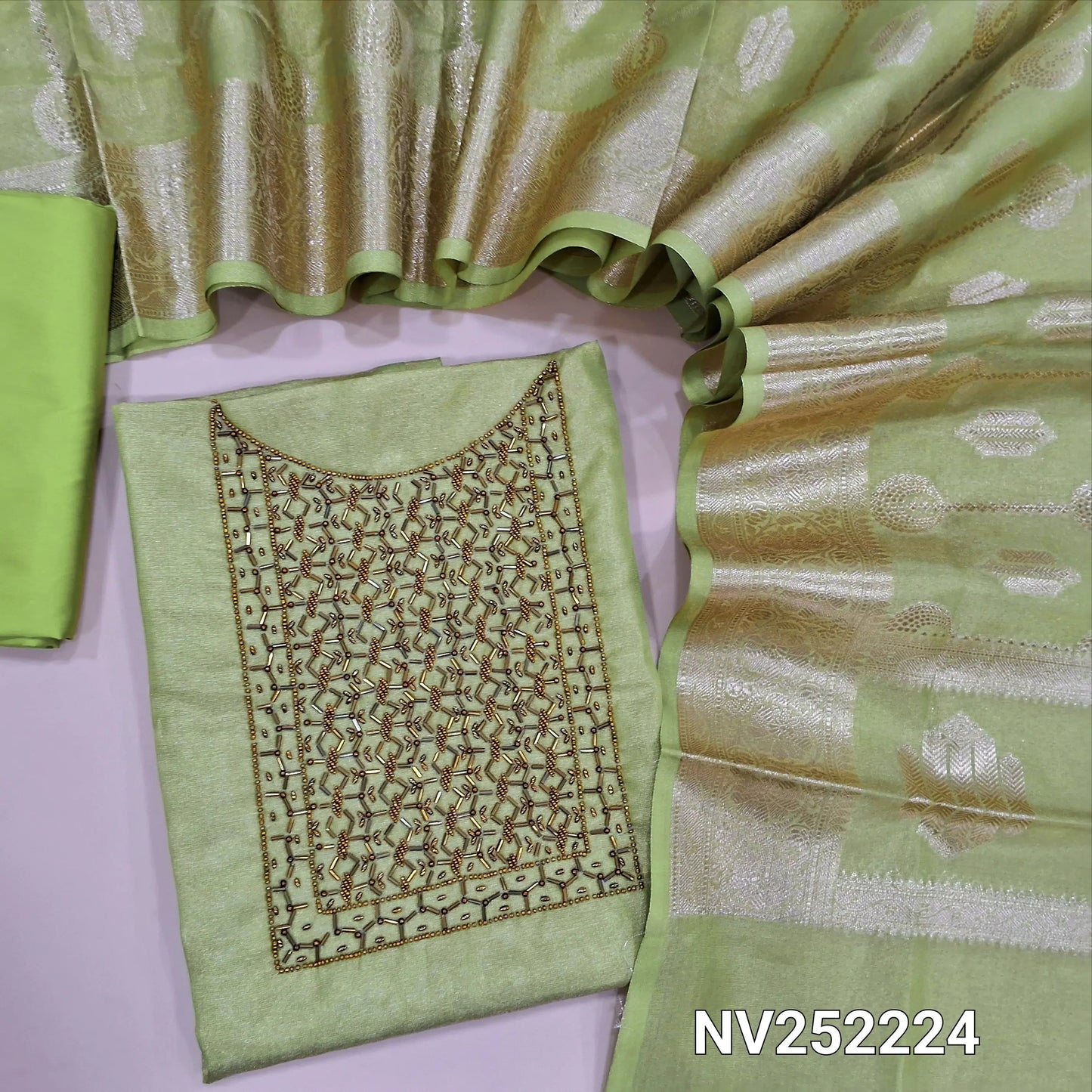 Light green with golden tint tissue silk cotton unstitched salwar material, cut bead and sugar bead work on yoke ( Lining Needed) Matching silk cotton bottom, rich benarasi woven tissue silk cotton full length dupatta with borders and tassles. NV252224
