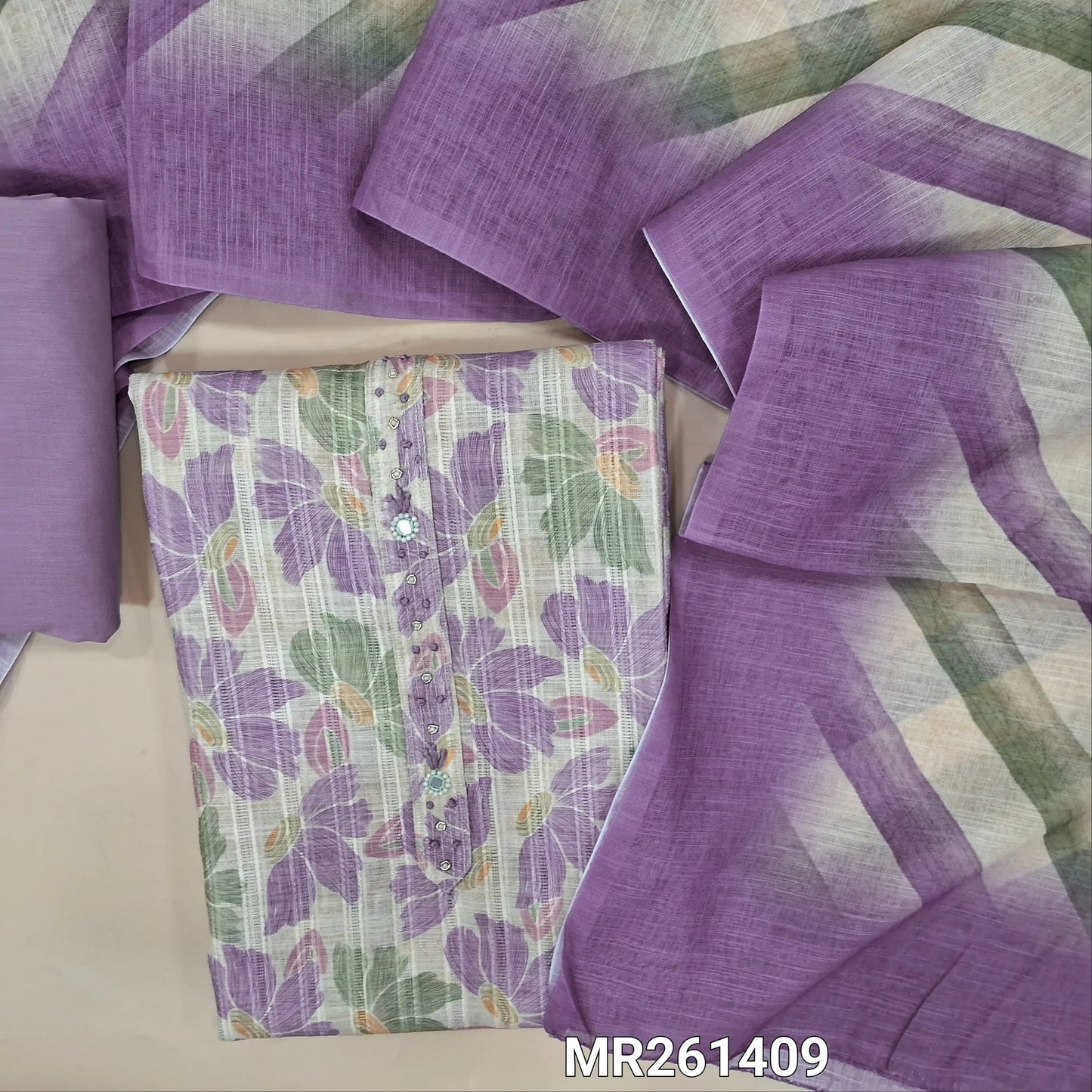 Half white jakard linen unstitched salwar material,zarodzi, french knot and mirror work on yoke, pastel shaded floral design all over,(lining needed)purple cotton bottom, Lehariya printed semi linen dupatta. MR261409