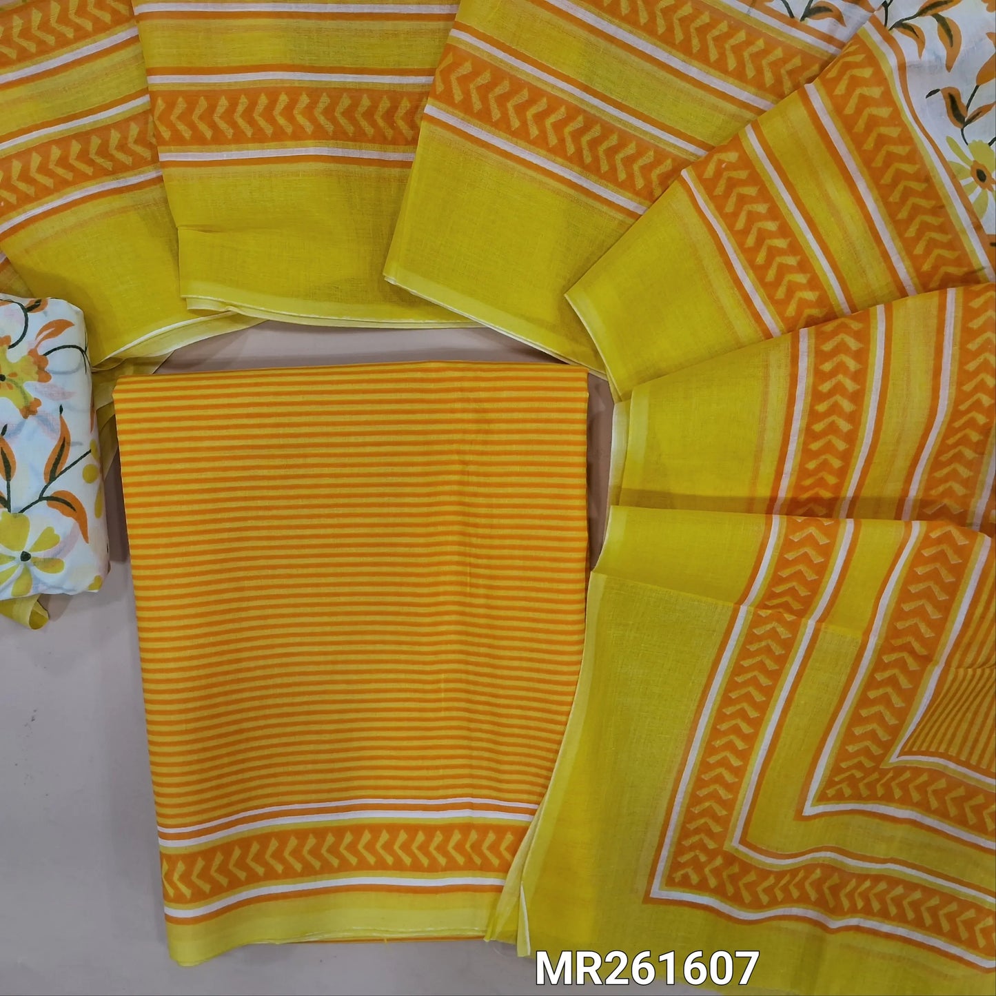 Bright yellow cambric cotton unstitched salwar material,vertical stripes all over,(lining optional)floral printed cambric cotton bottom, floral printed full length cambric cotton dupatta with pallu and printed borders. MR261607