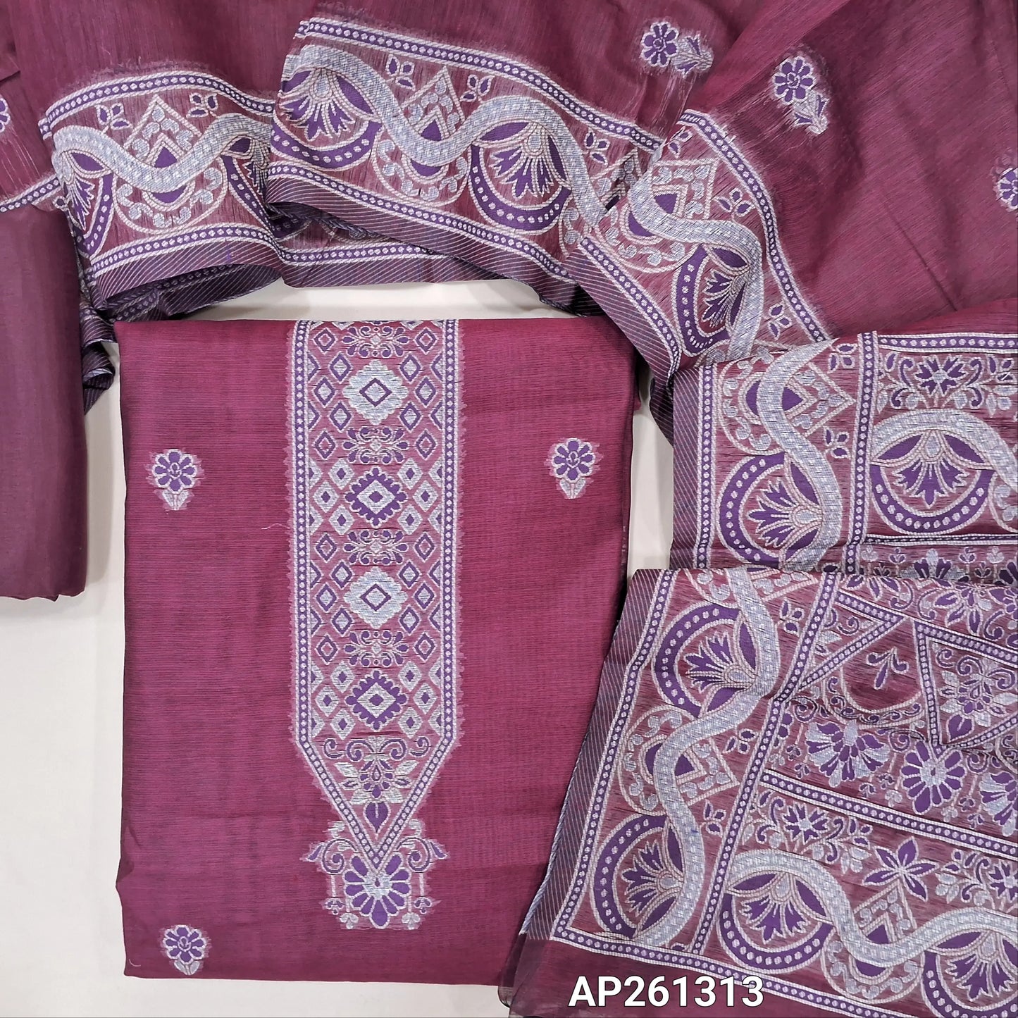 Beetroot purple silk cotton unstitched salwar material, floral buttas on front,thread weaving design on yoke and daman, (Silky, Lining Needed) silky bottom,buttas on silk cotton dupatta with rich thread weaving on pallu and borders. AP261313