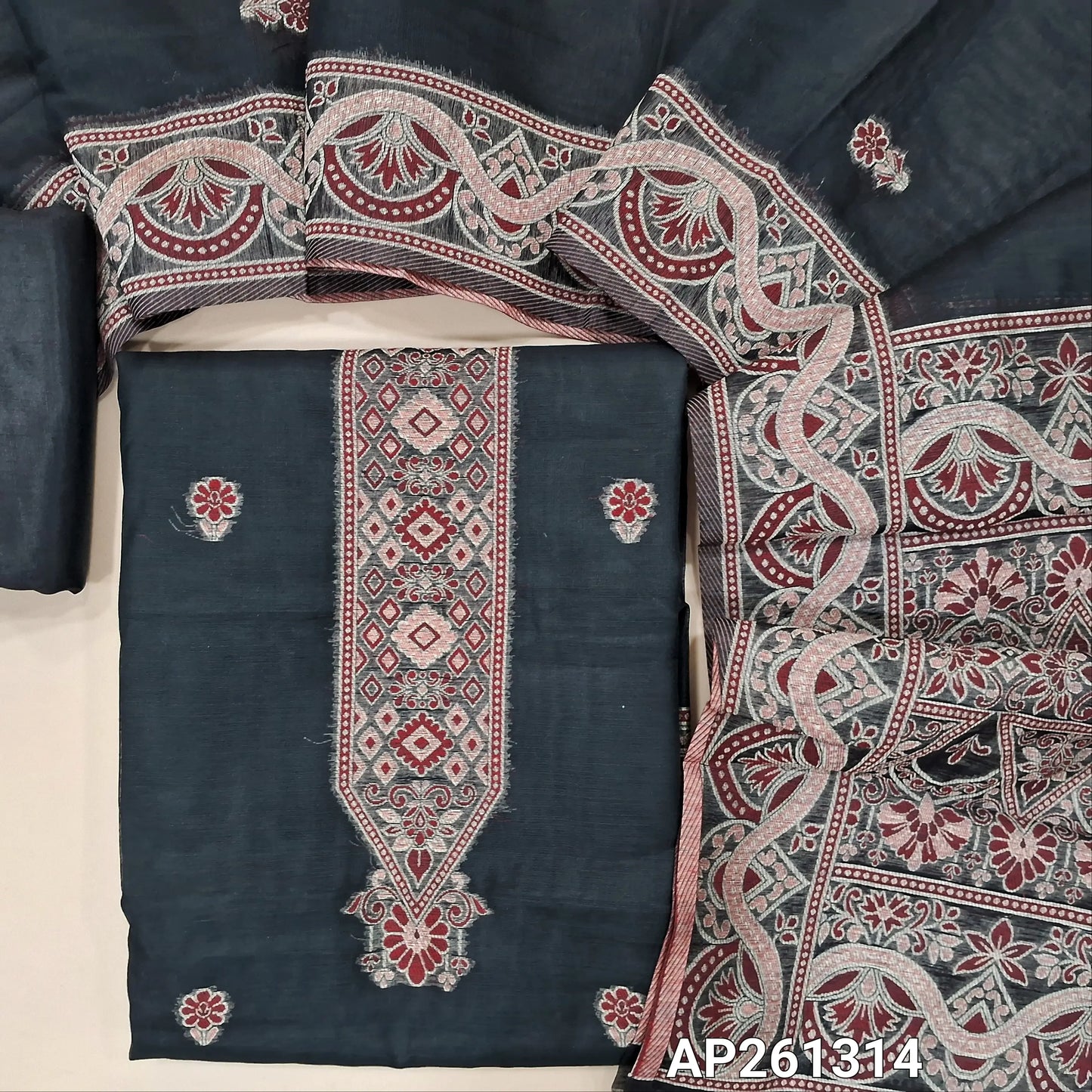 Black silk cotton unstitched salwar material, floral buttas on front,thread weaving design on yoke and daman, (Silky, Lining Needed) silky bottom,buttas on silk cotton dupatta with rich thread weaving on pallu and borders. AP261314