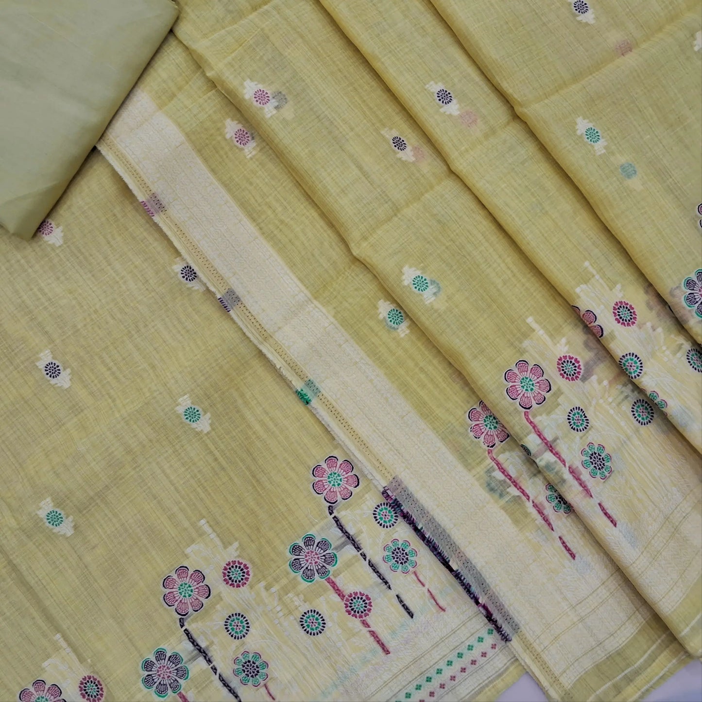 Pastel yellow silk cotton unstitched salwar material,thread buttas on front,thread weaving on yoke and daman,(Silky, Lining Needed)matching silky bottom, floral buttas on silk cotton dupatta with thread weaving pallu and borders(TAPPING NEEDED). AP262208