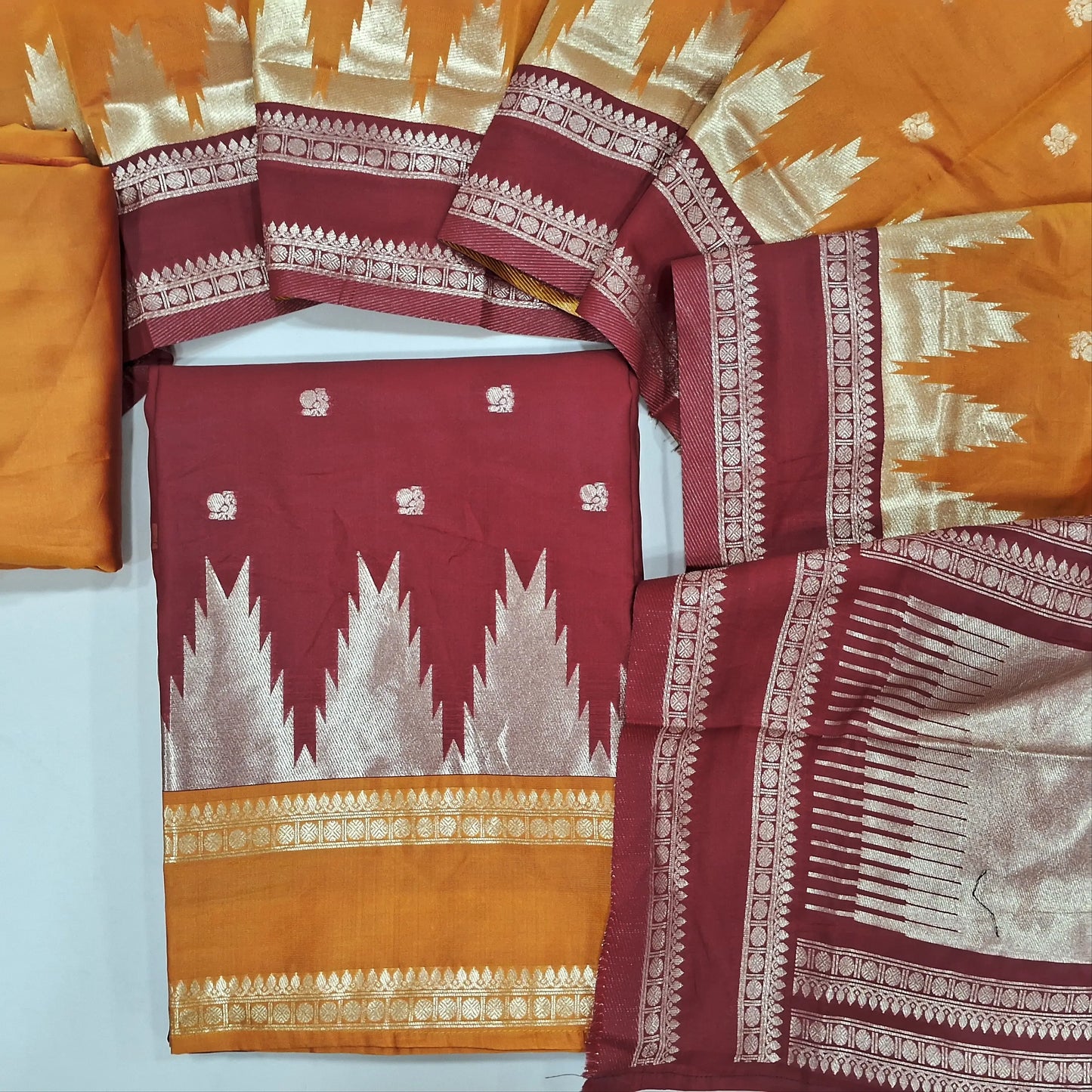 Reddish Maroon silk cotton unstitched salwar material,temple weaving, buttas on front,borders on daman, (lining needed) orange silky bottom,buttas on soft silk cotton dupatta with borders and tissue pallu. MY260802