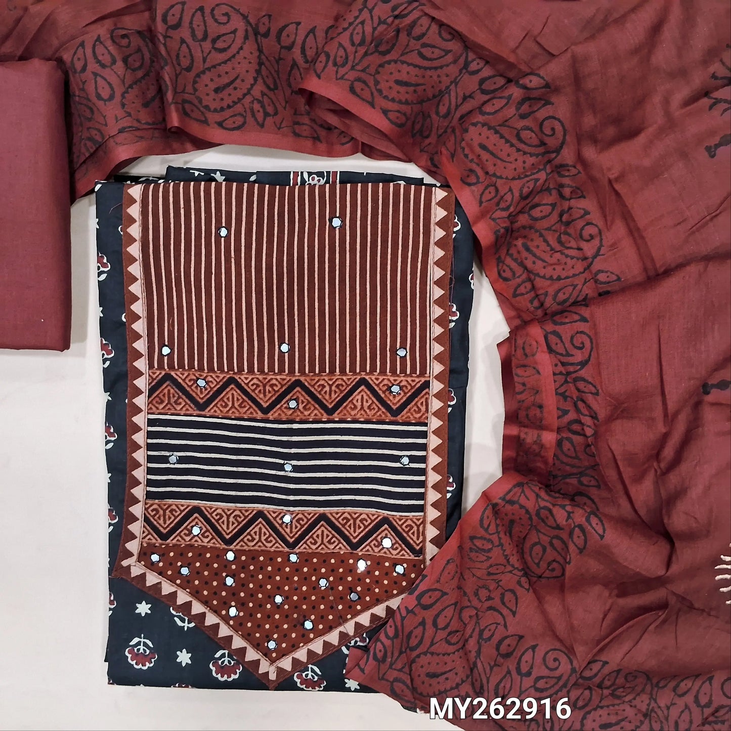 Black printed soft cotton unstitched salwar material, ajrak yoke patch with faux mirror work(lining optional)maroon cotton bottom,hand block printed mul cotton dupatta. MY262916