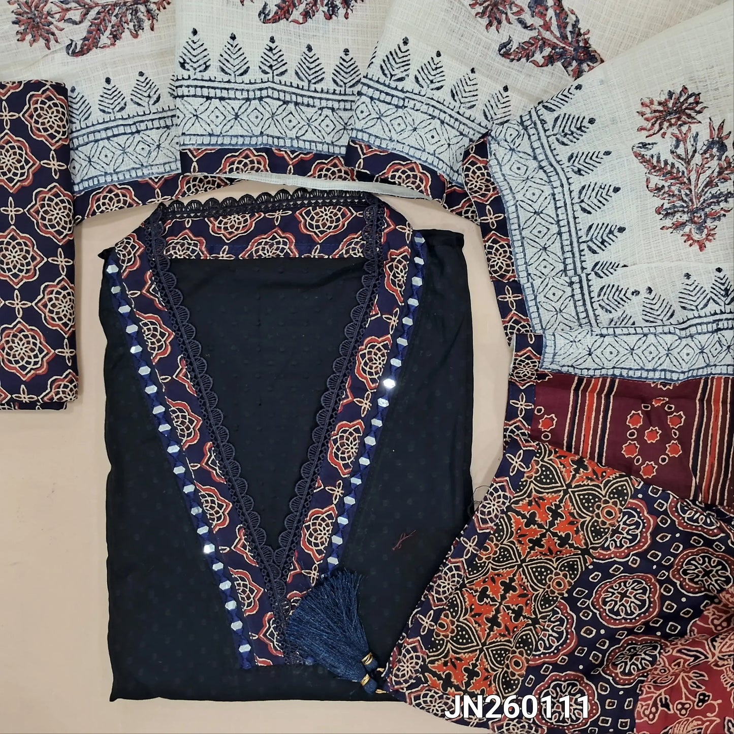 Black premium dobby cotton unstitched salwar material,collar neck with ajrak &real mirror work on yoke, self woven design all over(lining needed) dark blue block printed cotton bottom, block printed kota dupatta with applique work on pallu. JN260111