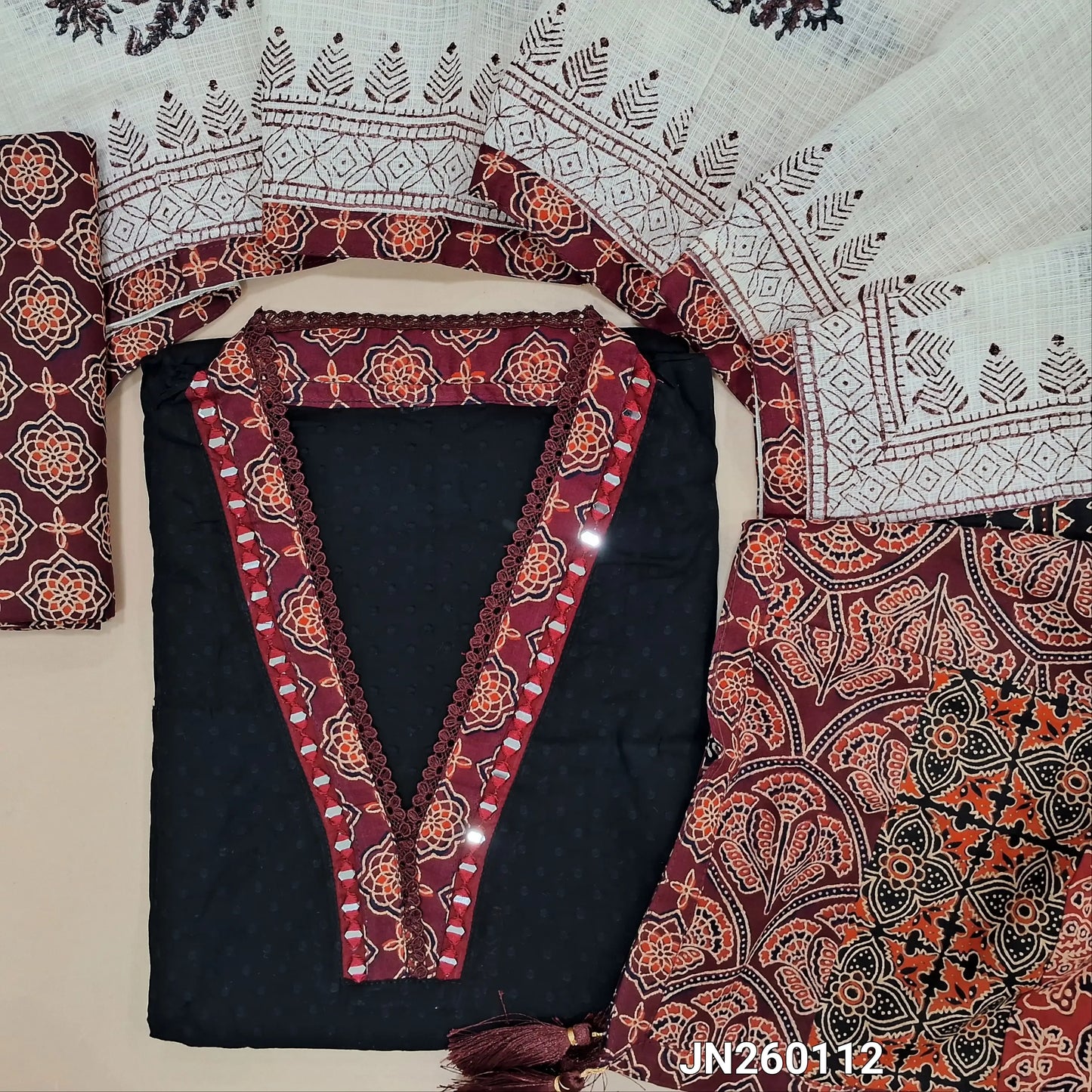Black premium dobby cotton unstitched salwar material,collar neck with ajrak &real mirror work on yoke, self woven design all over(lining needed) deep wine block printed cotton bottom, block printed kota dupatta with applique work on pallu. JN260112