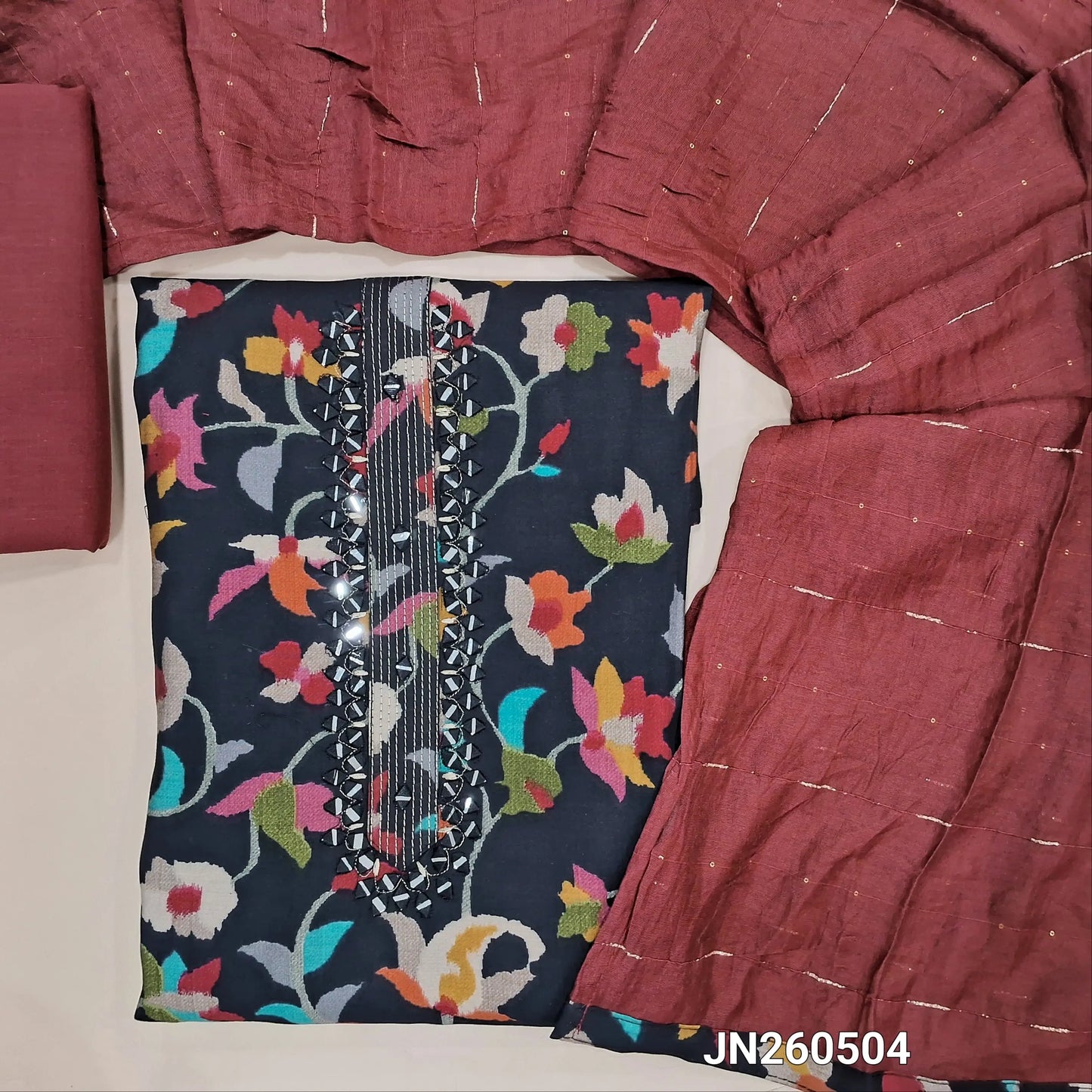Black floral printed soft silk cotton unstitched salwar material,zari lines and real mirror work on yoke( soft,textured,lining optional)maroon cotton bottom, zari lines and sequins work on soft silk cotton short width dupatta. JN260504