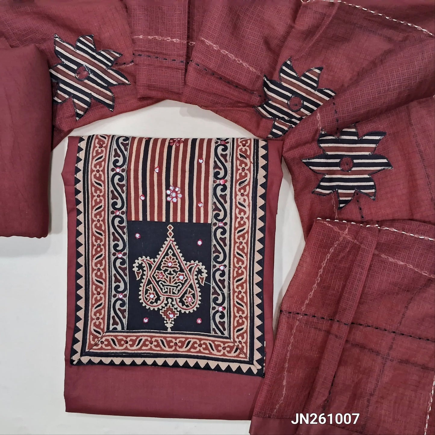 Dark maroon premium dabu cotton unstitched salwar material,hand block prints & ajrak yoke patch with faux mirror work on yoke(lining optional)matching spun cotton bottom, floral applique work on kantha stitch detailing & kota dupatta. JN261007