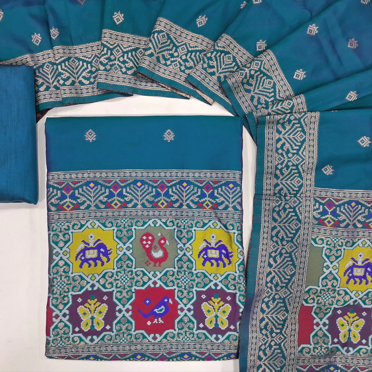 Peacock blue premium silk unstitched salwar material (lining needed) benarasi woven & meenakari weaving on yoke & daman, matching silk cotton bottom, premium silk cotton full length dupatta with meenakari weaving design pallu. JN262101