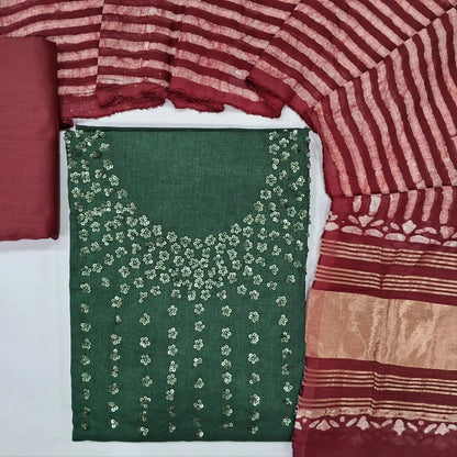 Dark green silk cotton unstitched salwar material (textured, lining needed) floral sequins work on yoke, maroon bottom, batik fancy silk cotton dupatta.(TAPPING NEEDED) JN262104