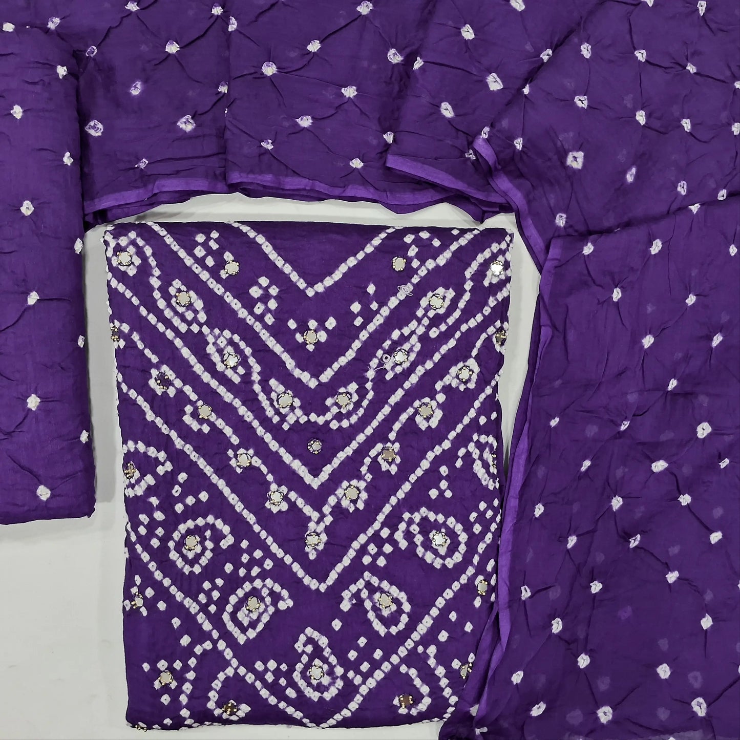 Purple bandhini unstitched salwar material,dye and dyed &bead, real mirror work on yoke,(lining needed)dye and dyed bottom, bandhini pure cotton dupatta. JN262105