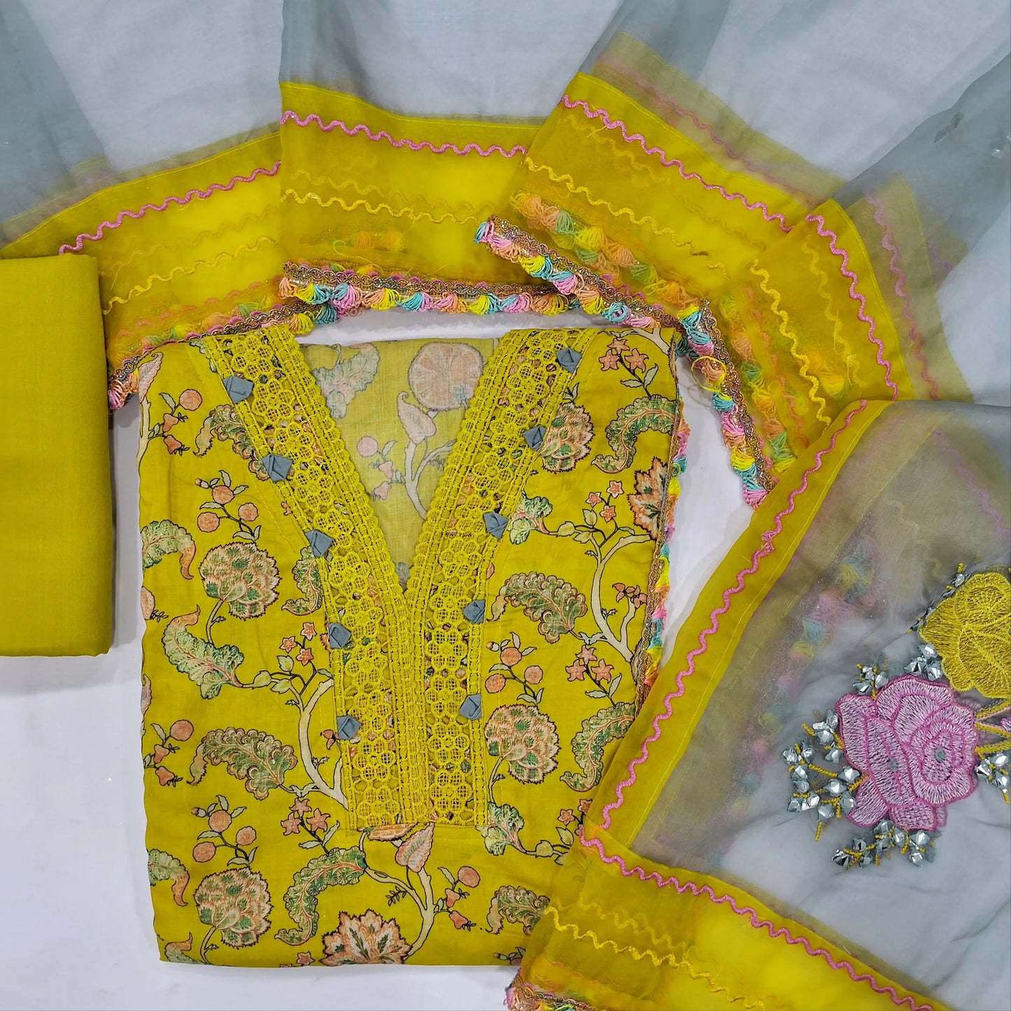 Mehandhi yellow soft silk cotton unstitched salwar material (lining needed)v neck on yoke with lace detailing,penal design, spun cotton bottom, floral embroidery fancy organza dupatta with lace tapping.JN262102