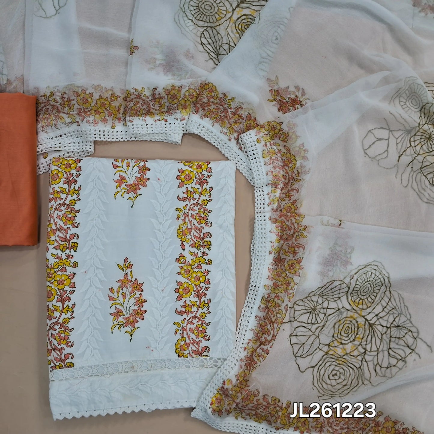 White cotton unstitched salwar material, hand block printed and self embroidery work on front,(lining needed) peach silk cotton bottom,block printed chiffon dupatta with tapping. JL261223