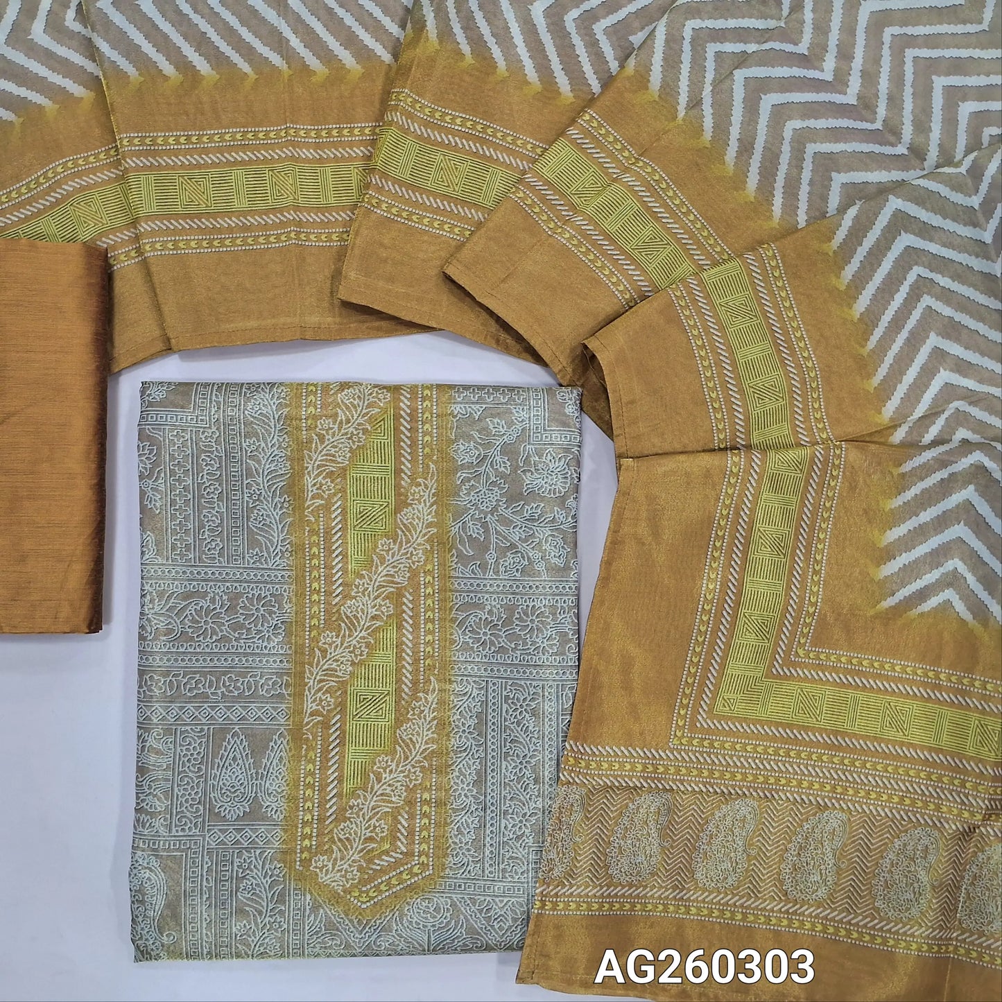 Rich golden beige with golden tint printed tissue silk cotton unstitched salwar material,(lining needed)mehandhi yellow silk cotton bottom, zig zag printed tissue silk cotton dupatta with contrast borders. AG260303