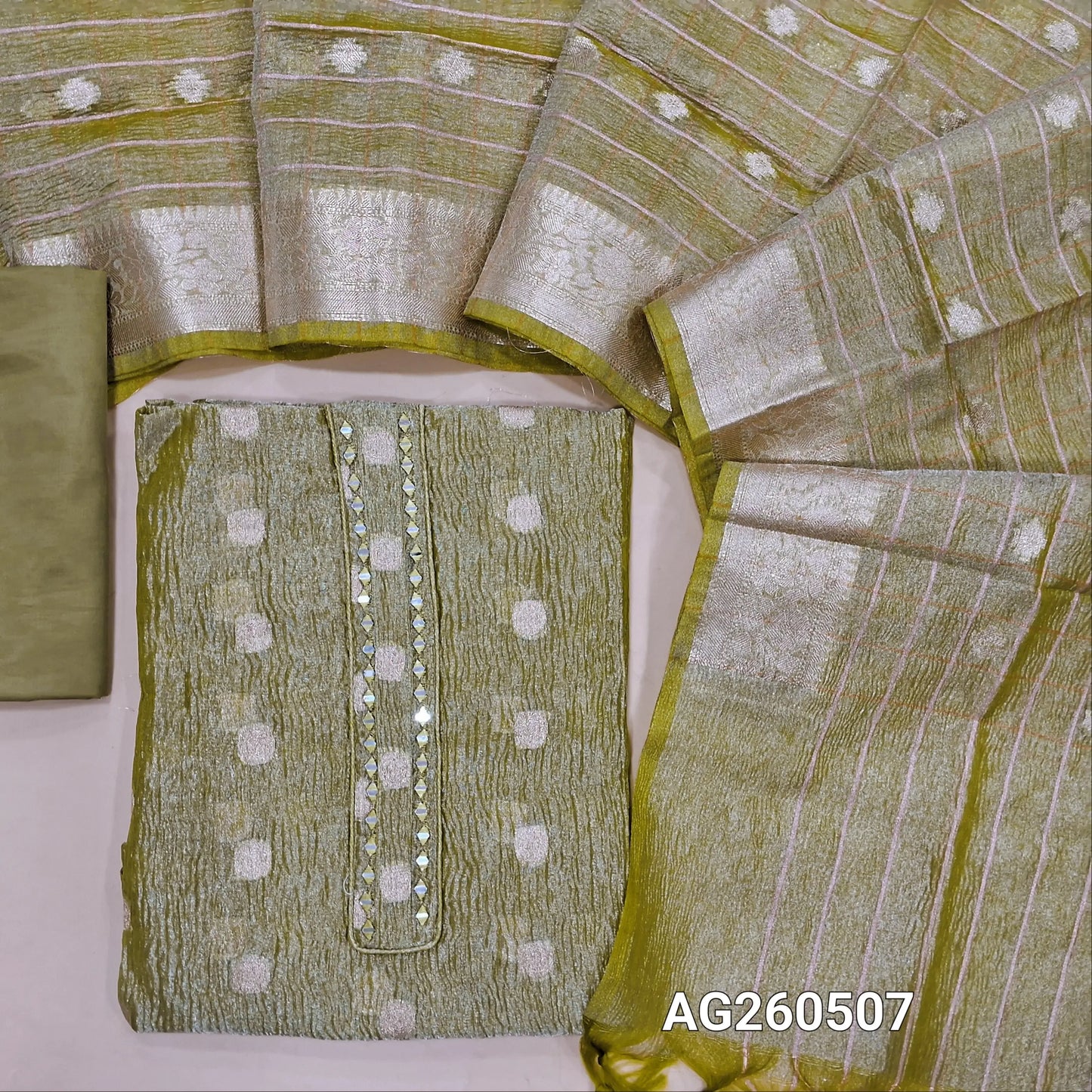 Pastel green with golden tint crinkled tissue silk cotton unstitched salwar material,mirror on yoke, buttas all over,(thin, lining needed)silky/silk cotton bottom, zari woven on crinkled tissue silk cotton dupatta with borders. AG260507