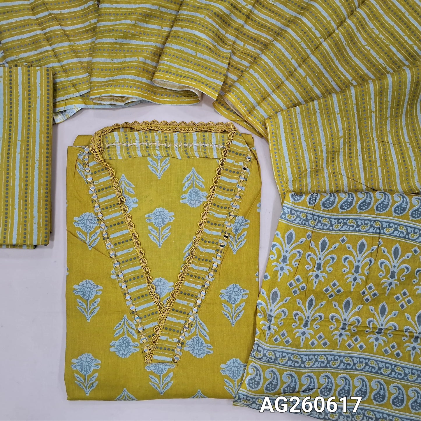 Mehandhi yellow printed pure cotton unstitched salwar material,v collar neck with real mirror and lace work (lining optional)printed cotton bottom, printed full length mul cotton dupatta with pallu. AG260617