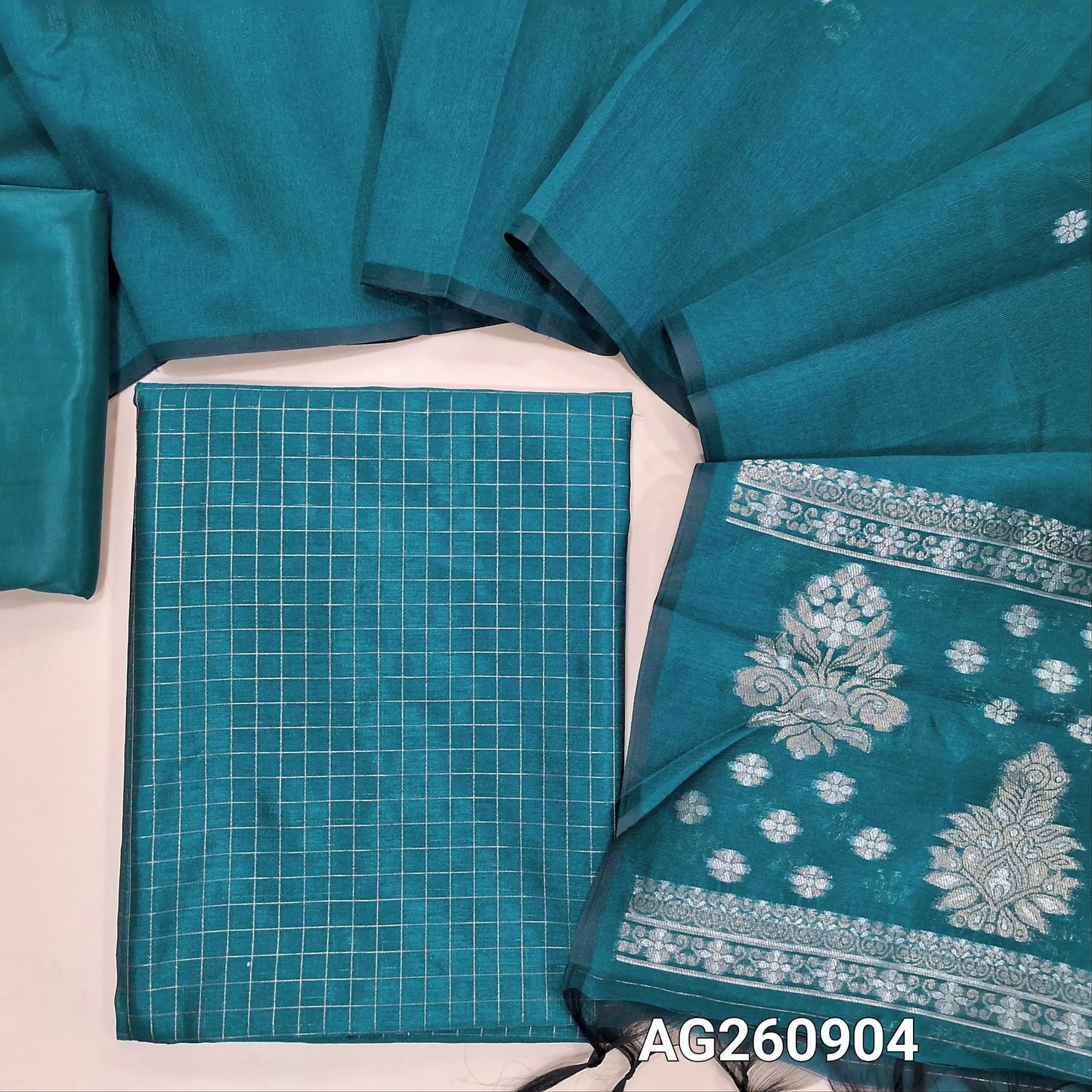 Teal blue silk cotton unstitched salwar material,zari checks all over,(Lining Needed)silky bottom, buttas on full length silk cotton dupatta with rich gold and silver zari pallu. AG260904