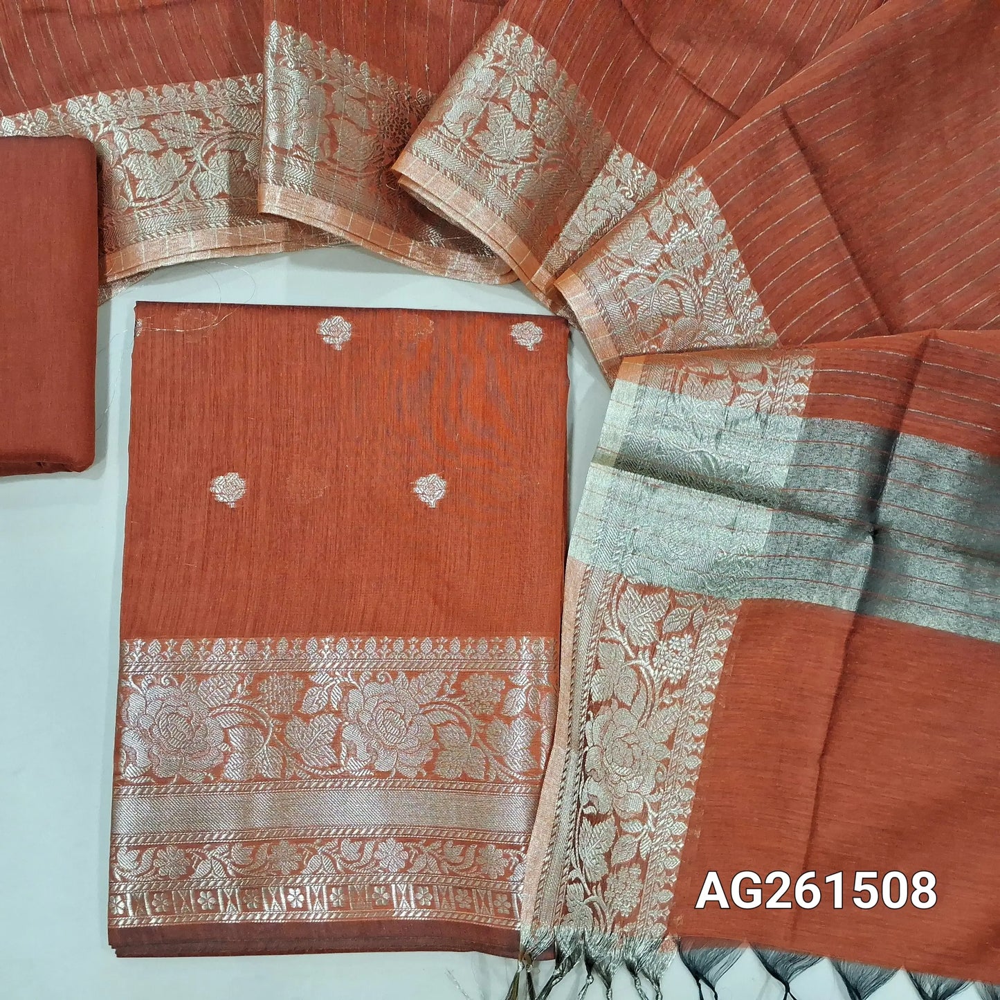 Rust orange benarasi silk cotton unstitched salwar material,checked design on yoke,buttas on front,antic gold zari weaving daman,(Lining Needed)silk cotton bottom,zari lines on silk cotton dupatta with tissue pallu and borders. AG261508