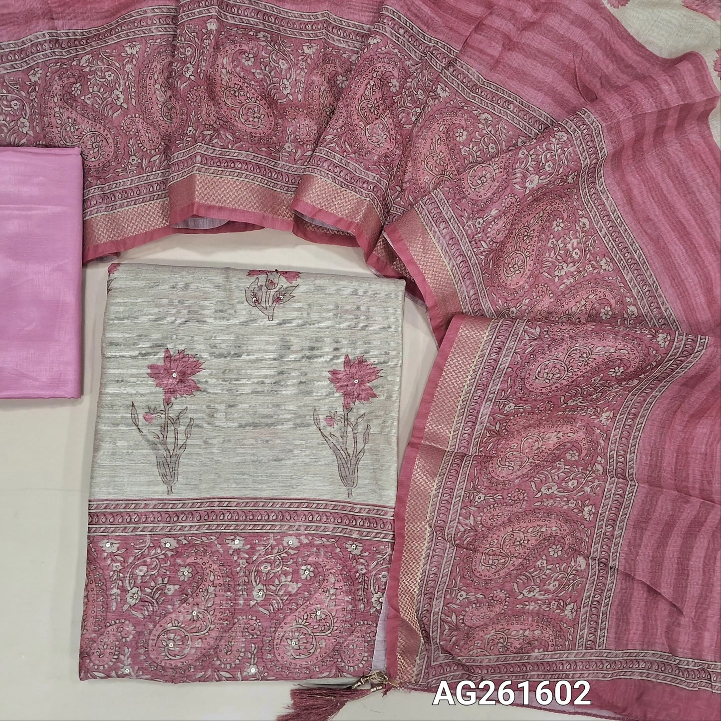 Beige semi jute silk cotton unstitched salwar material, floral printed with sequins work on front,( lining needed)lpink silky bottom,digital printed semi jute silk cotton dupatta with zari woven borders. AG261602