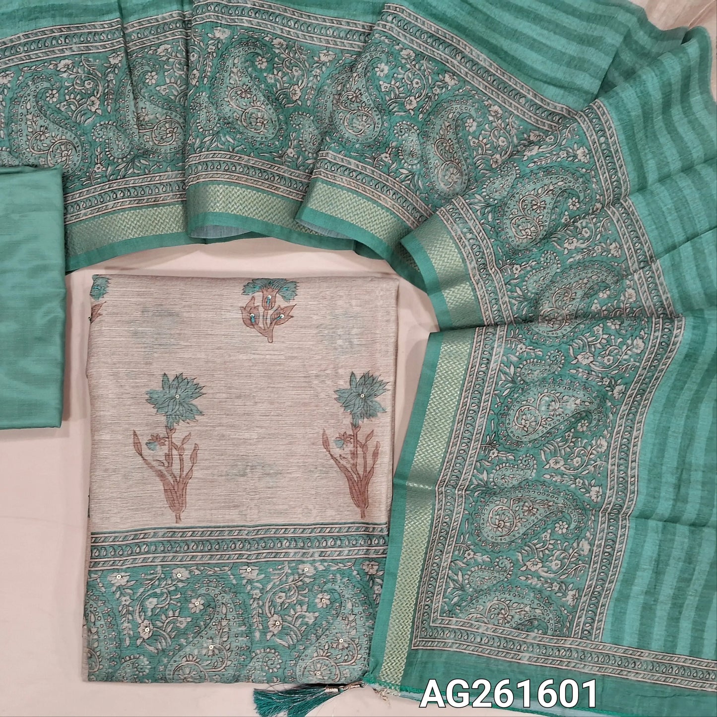 Beige semi jute silk cotton unstitched salwar material, floral printed with sequins work on front,( lining needed)turquoise green silky bottom,digital printed semi jute silk cotton dupatta with zari woven borders. AG261601
