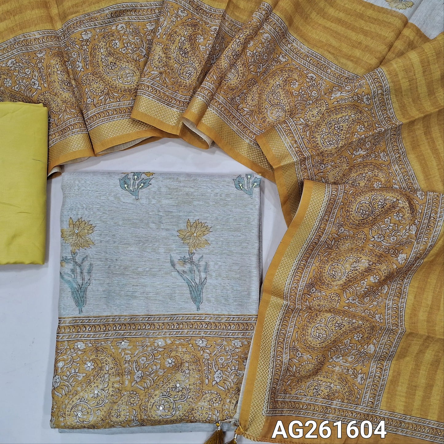 Beige semi jute silk cotton unstitched salwar material, floral printed with sequins work on front,( lining needed)yellow silky bottom,digital printed semi jute silk cotton dupatta with zari woven borders. AG261604
