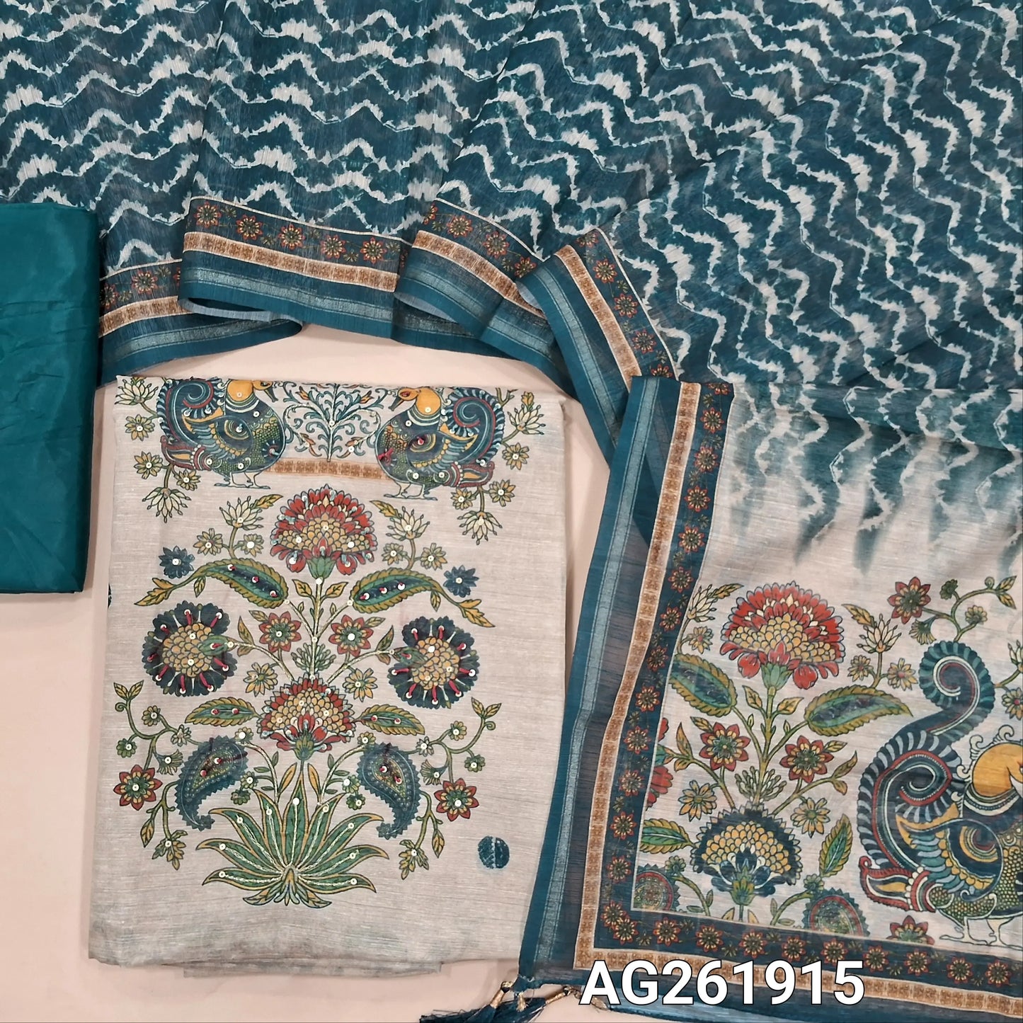 Beige semi jute silk cotton unstitched salwar material, digital printed with sequins work on daman,( lining needed)teal blue silky bottom,zig zag printed semi jute silk cotton dupatta with kalamkari pallu. AG261915