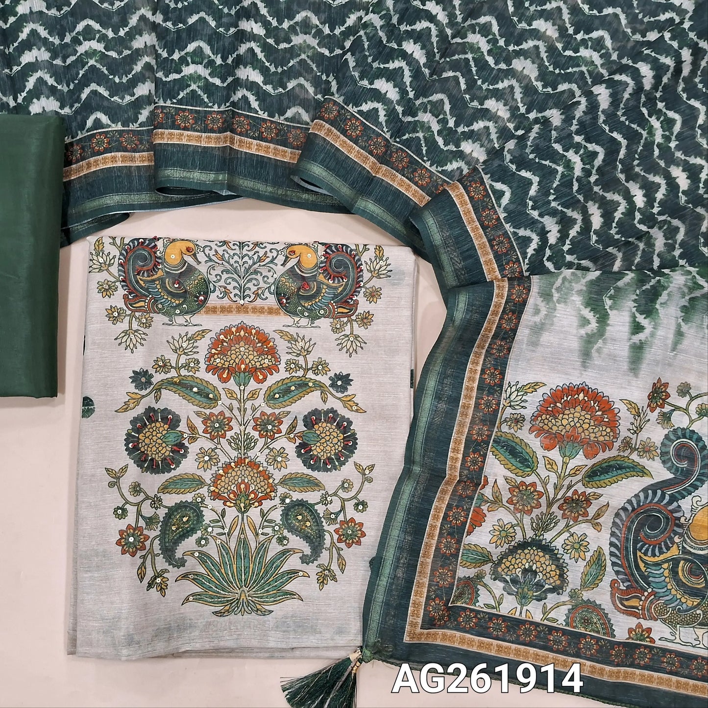 Beige semi jute silk cotton unstitched salwar material, digital printed with sequins work on daman,( lining needed)dark green silky bottom,zig zag printed semi jute silk cotton dupatta with kalamkari pallu. AG261914