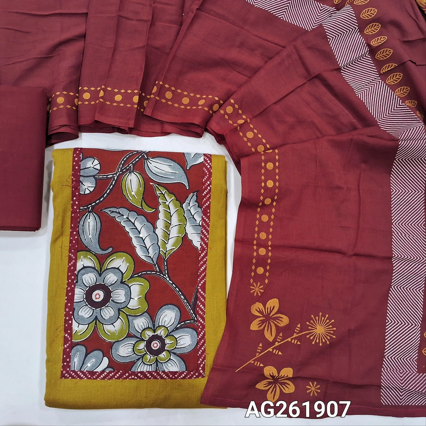 Yellow pure cotton unstitched salwar material,kalamkari yoke patch with kantha stitch, sequins and mirror work,(lining optional)reddish maroon cotton bottom,hand block printed soft mul cotton dupatta. AG261907