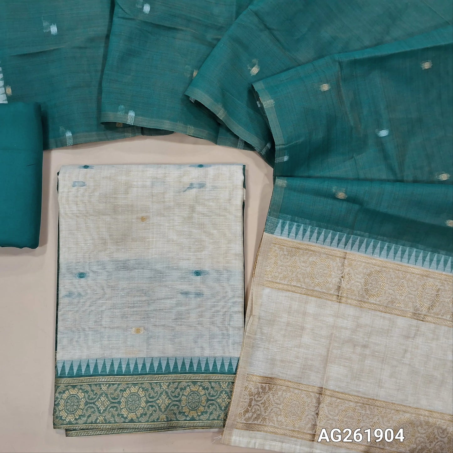 Off white silk cotton unstitched salwar material,contrast yoke with zari weaving border, gap border on daman,(Lining Needed)teal blue spun cotton bottom, silk cotton dupatta with contrast pallu with gap borders. AG261904