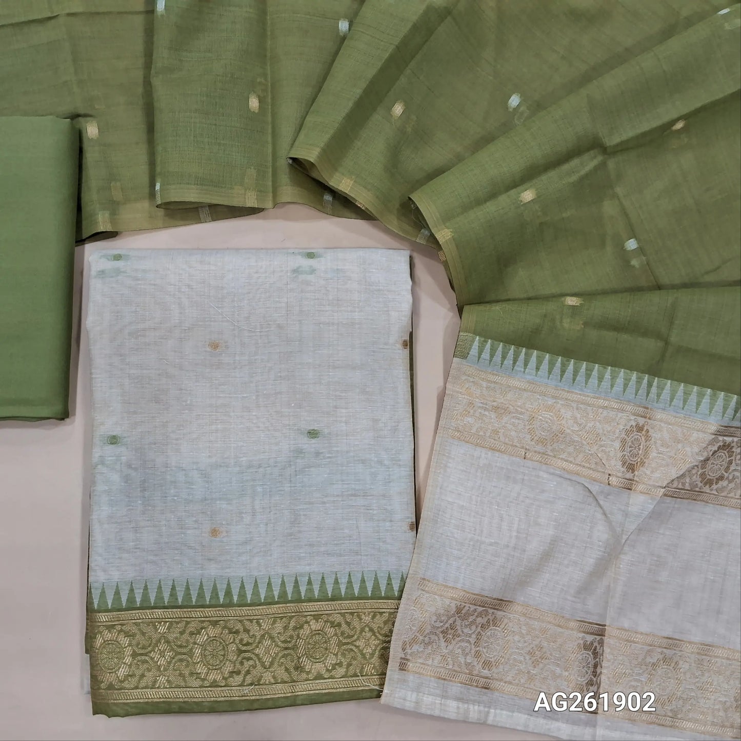 Off white silk cotton unstitched salwar material,contrast yoke with zari weaving border, gap border on daman,(Lining Needed)green spun cotton bottom, silk cotton dupatta with contrast pallu with gap borders. AG261902