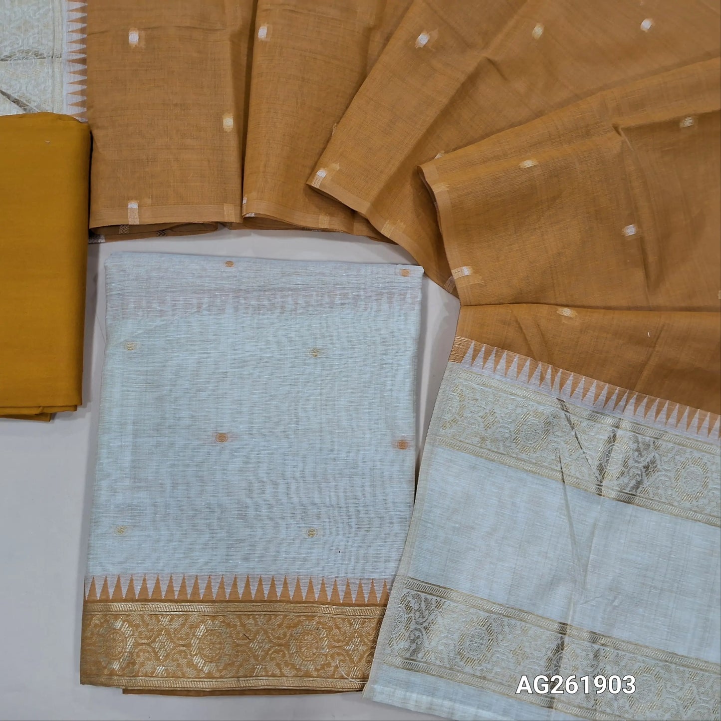 Off white silk cotton unstitched salwar material,contrast yoke with zari weaving border, gap border on daman,(Lining Needed)mehandhi yellow spun cotton bottom, silk cotton dupatta with contrast pallu with gap borders. AG261903