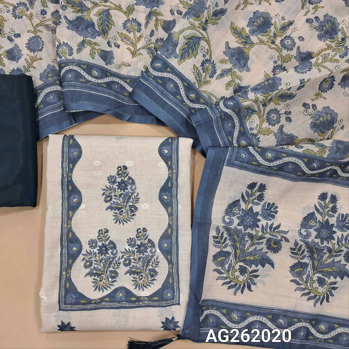 Off white base semi linen unstitched salwar material,floral printed  with zari & sequins on yoke,zari woven buttas and printed all over,(thin, lining needed)dark teal blue silky bottom,floral printed semi linen dupatta. AG262020