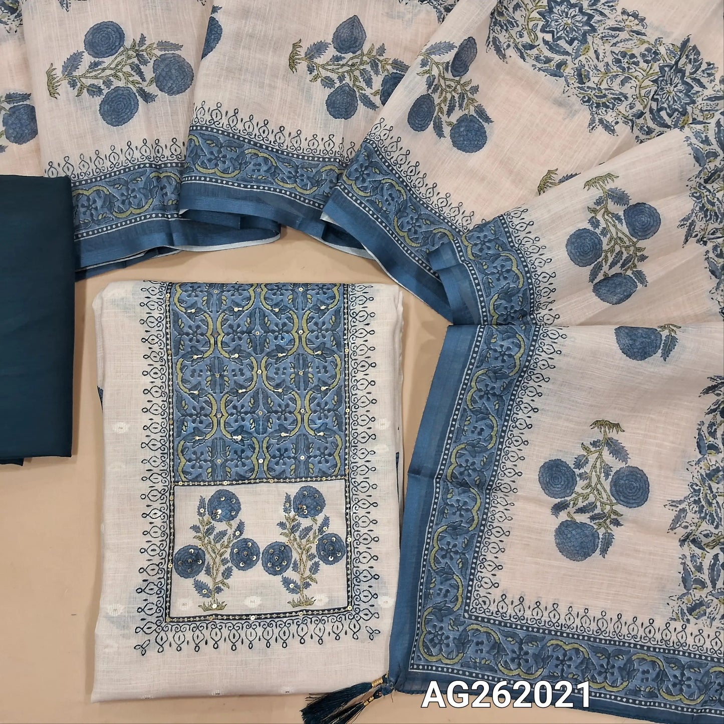 Off white base semi linen unstitched salwar material,floral printed  with zari & sequins on yoke,zari woven buttas and printed all over,(thin, lining needed)dark teal blue silky bottom,floral printed semi linen dupatta. AG262021