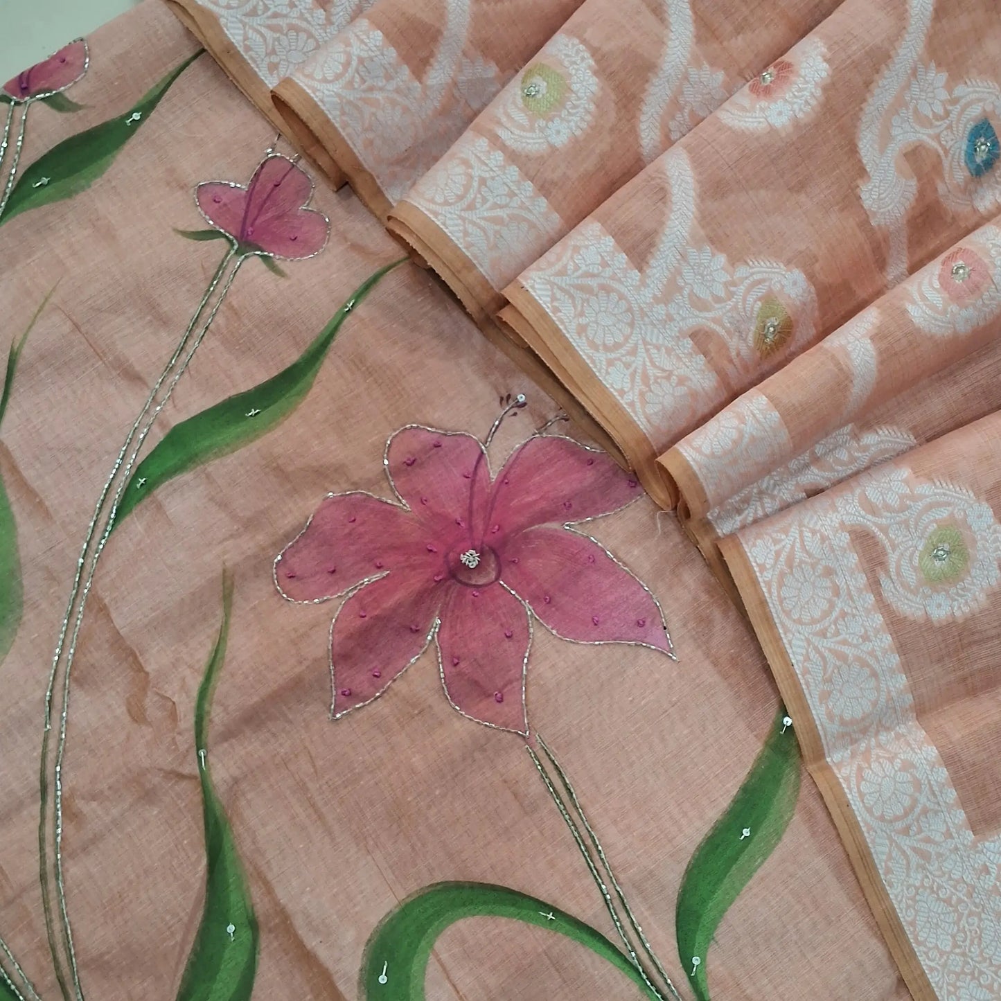 Peachish Pink premium muga silk cotton unstitched salwar material, hand brush paint work on front with cut bead detailing (Lining Needed) matching santoon bottom, rich jamdani and meenakari woven muga silk cotton dupatta with cut bead work. AG262201