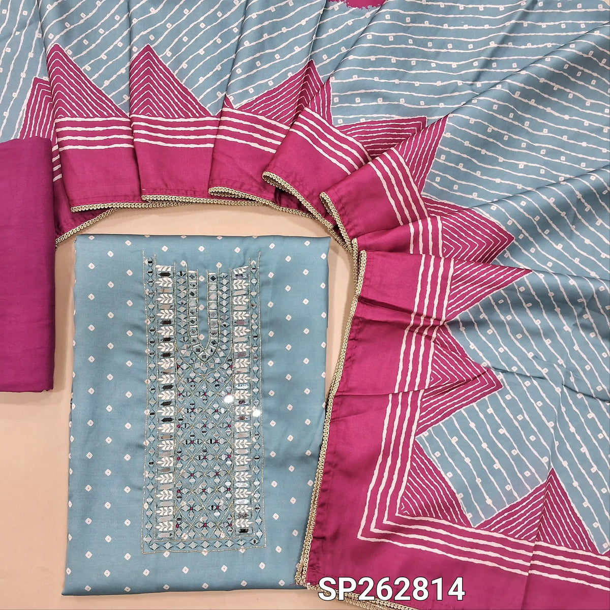 Powder blue pure gaiji silk unstitched salwar material, bandhini printed all over,real mirror and thread work on yoke, (HEAVY FABRIC)pink santoon bottom, printed gaiji silk dupatta with tapping. SP262814
