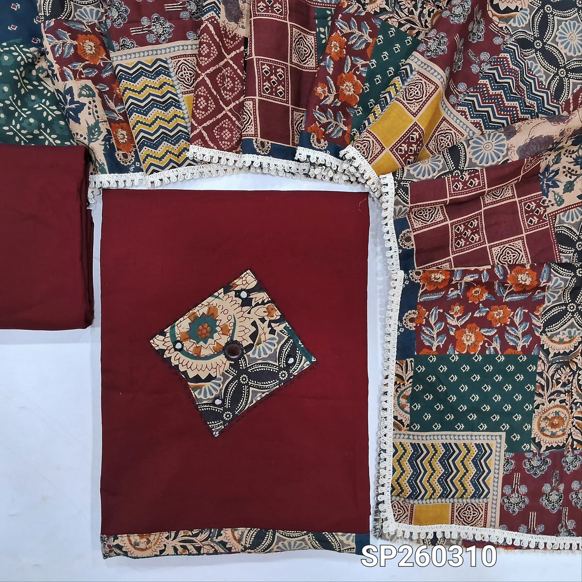 Maroon designer dabu cotton unstitched salwar material, applique and mirror work on yoke and daman (Lining Optional) matching bottom, printed mul cotton dupatta, printed dabu cotton over coat. SP260310
