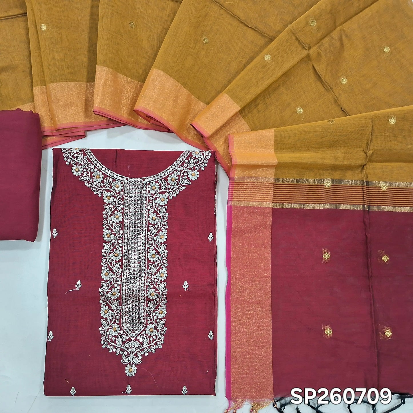 Maroon and mehandhi yellow silk cotton unstitched salwar material, zari and sequins detailing on yoke and front (Thun, Lining Needed)matching spun cotton bottom, silk cotton dupatta with small zari buttas and contrast pallu. SP260709