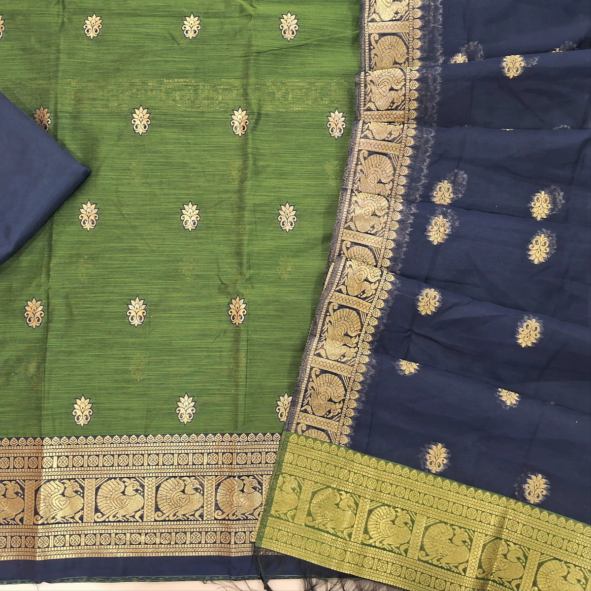 Olive green premium silk cotton unstitched salwar material,buttas all over benarasi zari weaving daman, (lining needed)dark blue silky bottom,buttas on silk cotton dupatta with pallu and borders. SP261806