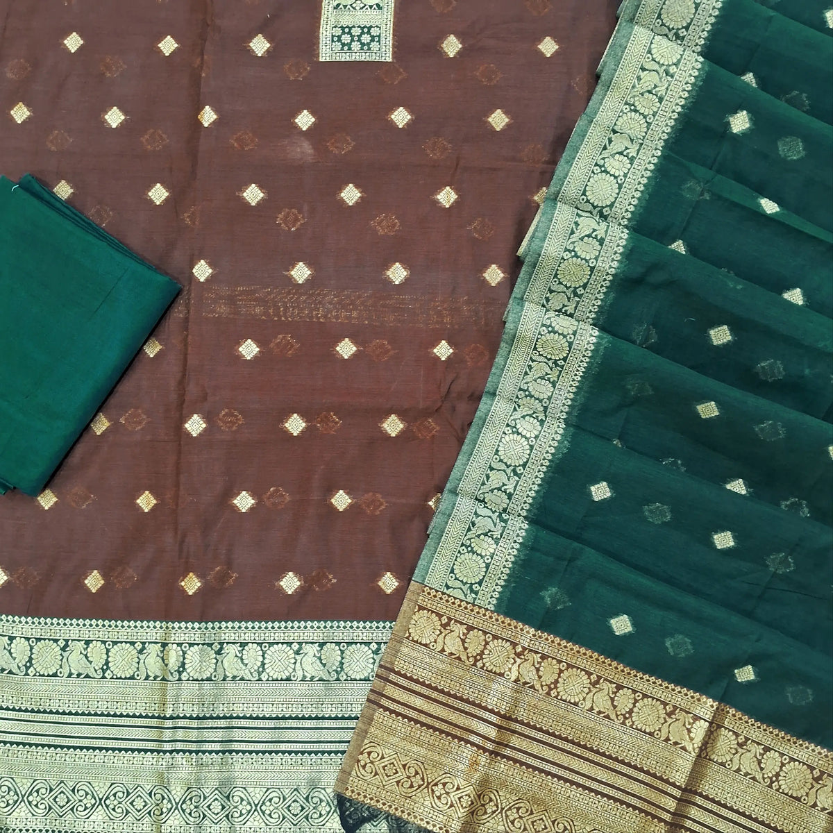 Dark brown silk cotton unstitched salwar material,benarasi zari weaving on front, rich weaving daman,(lining needed)teal green silky bottom, zari weaving on silk cotton dupatta with contrast pallu and zari borders. SP262112